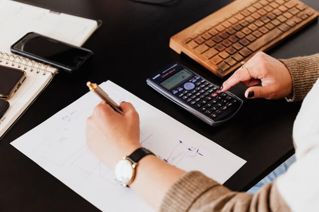 crop-woman-using-calculator-and-taking-notes-on-paper crop-woman-using-calculator-and-taking-notes-on-paper